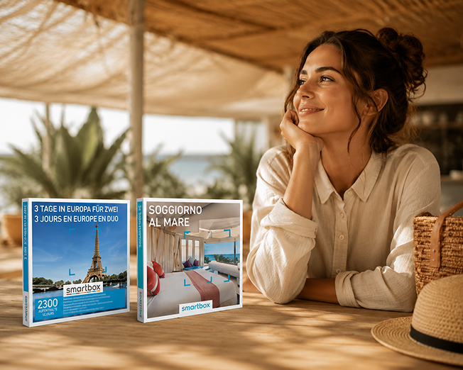 Una donna in vacanza accanto a due confezioni Smartbox